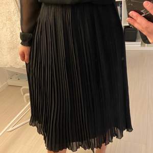 Svart plisserad kjol från NAKD i storlek 36! 