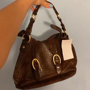 Vintage väska - Brun jättefin väska från Benetton köpt secondhand men aldrig kommit till använing så helt nytt skick därför ”skrynklig” på bild. Perfekta höst väskan!!!!