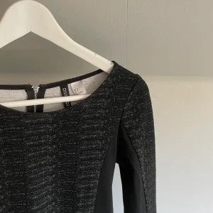 Långärmad klänning - En svart långärmad klänning med mönster. Klänningen är från HM och har en kort dragkedja baktill. Använd fåtals gånger. Vid funderingar hör gärna av dig. Köparen står för frakten💕💗