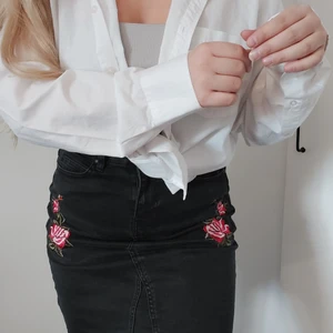 Kjol med brodyr  - Svart lite längre kjol med broderade blommor. Står ingen storlek men skulle säga M/L, stretchigt material. 