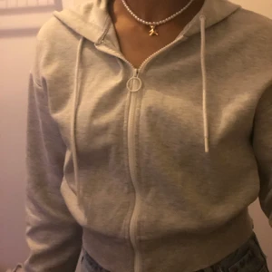 Grå hoodie - Grå hoodie med vit dragkedja från bershka. Hoodien är i bra skick och har storlek xs. !köparen står för frakten!