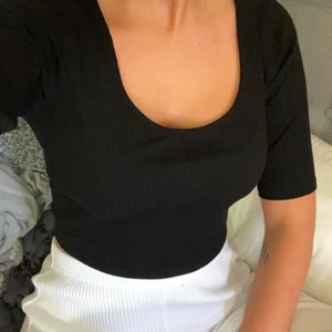 Svart ribbad topp - En svart ribbad topp med lite längre armar för att vara en kortärmad säljes nu. Väldigt sparsamt använd och i storlek S. Fri frakt. 