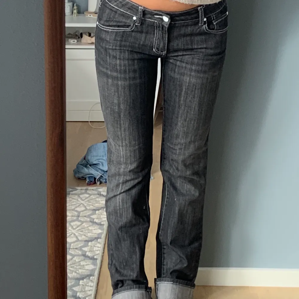 Lågmidjade svarta jeans med vita sömmar. Raka i modellen. Jag är 166cm lång och dom är lite långa på mig. Viker därför upp byxorna som på bilden. Jag har vanligtvis storlek 26 i midjan och de passar bra på mig. . Jeans & Byxor.