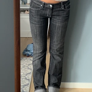 Jeans svarta lågmidjade - Lågmidjade svarta jeans med vita sömmar. Raka i modellen. Jag är 166cm lång och dom är lite långa på mig. Viker därför upp byxorna som på bilden. Jag har vanligtvis storlek 26 i midjan och de passar bra på mig. 