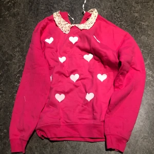 Rosa hjärtan tröja xs - Rosa tröjan med vita hjärtan och spetskrage. Omknyte i nacken. Så gullig och originell.