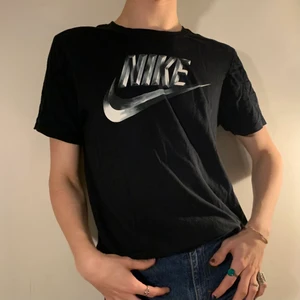 vintage svart Nike t-shirt metallic logo - Svart vintage Nike t-shirt med den coolaste silver metalliska 3D loggan på bröstet 📹 Det perfekta basic plagget för din garderob som spicear upp en outfit lagom mycket utan att göra den för överväldigande! Så snygg till ett år vanliga jeans och sneakers! Loggan är en av de coolaste jag sett och gör denna t-shirten så så unik!