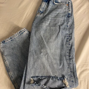 Blåa jeans - Ett par blåa jeans med hål på knäna från Ginatricot som aldrig är använda. De är i storlek 32 och petite💙