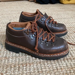 Naturkompaniet vandringssko 36/37 - Bruna låga läderkängor i ca storlek 36. Det står 37 i, men skulle säga att de är mindre. Innermått 22,5-23cm. Vibram-sula i fint skick. Äldre slags vandringssko från naturkompaniet.