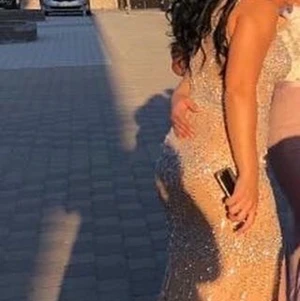 Glittrig klänning - Klänningen är köpt för ca 2 år sedan av en tjej, köpt för 4500 och säljer den för mindre än halva priset. Använt den endast en gång till ett bröllop och det var de bästa valet jag kunde gjort. Klänningen sitter jättefint på och strålar på dansgolvet. Klänningen kommer i en stor påse som gör att klänningen inte blir skrynklig eller så. Köparen står för frakten💗