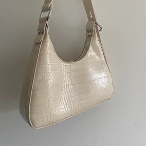 Väska  - Beige väska med krokodilmönster. Bra kvalité och använd endast fåtal gånger. Pris kan diskuteras. Kan fraktas och då står köparen för fraktavgiften🤍