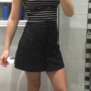 Kjol i stl 34 - Detta är en fejkskinn kjol med svarta knappar. Denna är vädligt bekväm och snygg på.