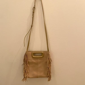 Maje väska  - En beige väska från maje. Köpt i Nice. Sparsamt använd, och i fint skick. Säljer pga används inte längre. Dustbag tillkommer💋