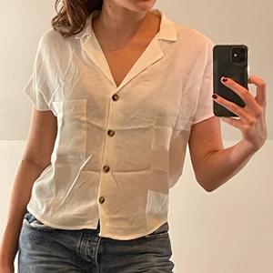Kortarmad sommarskjorta/blus - En vit/krämvit kortärmad blus eller skjorta från berska. Inte särskilt använd och bra skick. Den passar mig som är s/m trots att den är en xs💝