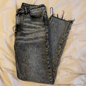 Gråa jeans med slitna detaljer från ONLY i storlek 29/34. Rak modell