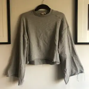 Säljer en grå, avklippt sweatshirt med vida ärmar från HM i storlek 34! Material: 75% polyester och 24% bomull! Skick: använd men inget att anmärka på! 