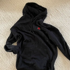 svart hoodie med ros från h&m - en svart hoodie med tryck på en ros på bröstet ❤️ sparsamt använd men lite sliten (det vita är katthår lol som jag självklart tar bort innan jag postar) 