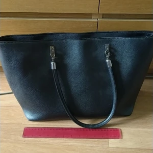 Svart väska - magnet stängning. Mittback och fickor på sidorna. Perfekt storlek för skolböcker och dator