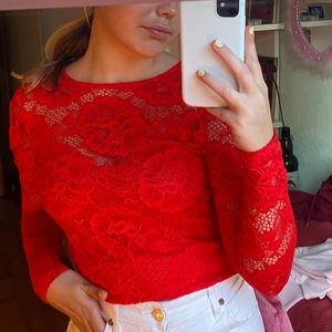 Superfin röd spetströja  - En jättefin lite festligare tröja i röd spets från gina tricot, storlek XS men passar även S och M. Som ni kan se är tröjan genomskinlig upptill med vid bysten och ner finns ett extra tyg inuti tröjan som inte är genomskinligt. Färgen på tröjan är som i den första bilden, väldigt starkt och en fin nyans av röd. Använd en gång!!