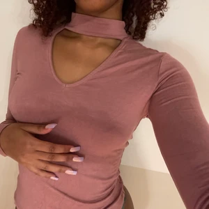 Rosa långärmade topp med choker 💓 - Säljer min rosa långärmade topp med choker köpt på garage!🥵   Den är aldrig använd och i bra skick! Materialet är väldigt stretchigt och skönt och chockern sitter inte åt! Skulle säga att det är en smutsrosa färg! Fråga gärna om ni behöver fler bilder osv! I’m here to help!😛😛 