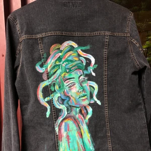 Svart jeansjacka med målat tryck stl 40 - * jackan är från flash jeans och är i väldigt bra skick                   * storleken är 40 men den sitter bra på mig (storlek 36/38)      🧚🏽nästan aldrig använd, endast för prövning av storlek                  🌵frakten ingår i priset/ bor du i Göteborg kan vi mötas upp🤠🐍baksidans motiv föreställer Medusa och är målat med textilfärg, jackan är även struken och färgen håller 40 grader i maskintvätt🧚🏽