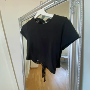 Tröja  med spets detalj i ryggen  - En superfin svart tröja med en underbar spets detalj i ryggen. 