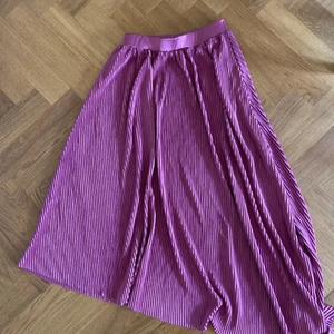 Rosa kjol - Pilserad rosa kjol i härligt material! Aldrig använd, storlek small 