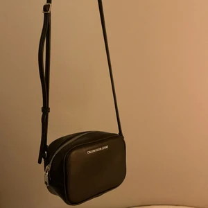 Så söt miniväska från Calvin Klein - Säljer min så så söta väska från Calvin Klein!! Den är knappt använd så den är i sin bästa form😇 Väskan har 3 hål att justera bandet till, men jag har gjort ett till hos en skomakare för att jag gillar min väska lite kortare🙏🏼