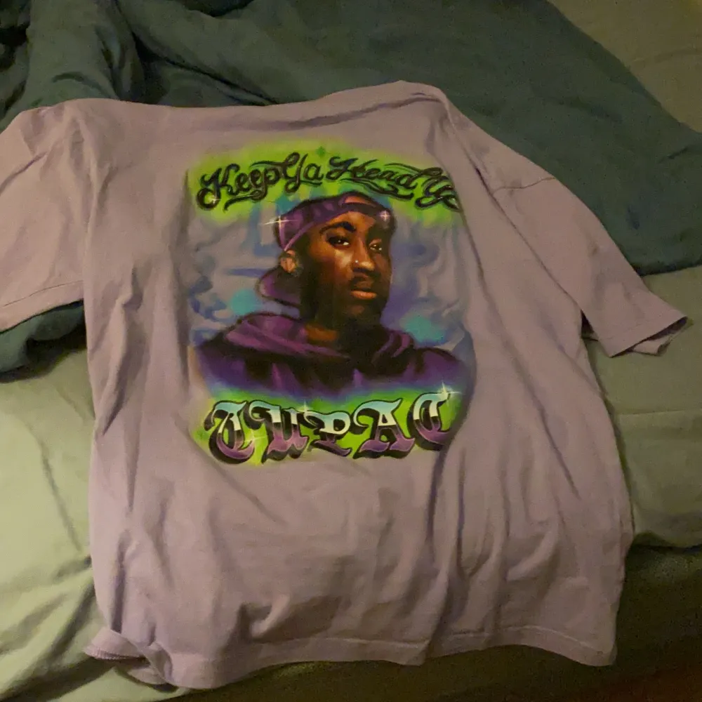 en ljus lila tshirt med tupac tryck. Vill bara kolla hur mycket jag kan få för den. T-shirts.