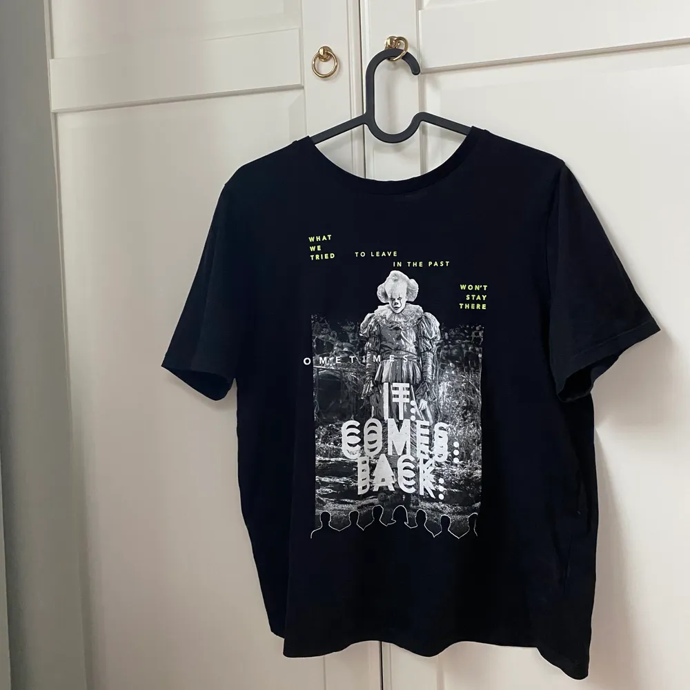 En svart t-shirt från H&M dividend med IT motiv. Använd men i bra skick . T-shirts.