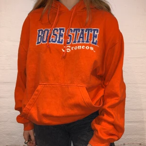 Boise State College Hoodie - Vi säljer denna orangea hoodie med broderat text där det står Boise State på. Priset är 349kr.  Den är i storlek L och sitter som en M/L. Personen på bilden är 165 och brukar ha på sig M. Inga defekter på hoodien. Kontakta oss på Plick eller på vår Instagram @wanderetro. Om flera visar intresse blir det budgivning. Köparen står för spårbar frakt på 66kr. 🤍