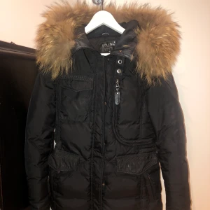 Hollies Livigno - En äkta Hollies jacka inköpt från Hollies i Stockholm. Modell: Livigno, storlek 36. Finns små sminkfläckar vid kragen men syns knappt. Äkta tvättbjörns päls på jackan men går självklart att byta/ta bort pälsen om man vill det. Säljer för 1500 men vid snabbt köp kan priset diskuteras. 