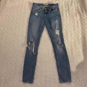 Tighta jeans med hål från Gina tricot i storlek W.24, modell Kristen 💜💜 Lågmidjade. Jeansen är i mycket fint skick och är använda enstaka gånger, säljer då jag inte kan ha dessa längre. Samfraktar gärna med andra plagg och betalning sker via Swish <33