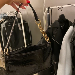 Väska från zalando - Super fin väska från zalando i svart med  orm mönster och guld detaljer på bandet, använd 1 gång och är som helt ny. Köptes för 400kr. Pris kan diskuteras💕