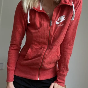 NIKE HOODIE - Hoodie från Nike köpt på nikebutiken i Köpenhamn. Suuupertunn och skön att ha både till vardags och träning. Går att dra upp hela vägen som på bild 2 eller ga den som på bild 1! Superluftig och en väldigt fin och ”snäll” röd färg. Köpte för 700kr