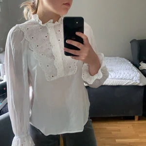 Vit blus - En vit blus i storlek 34. Funkar bra under västar, kavajer och liknande. Fina detaljer