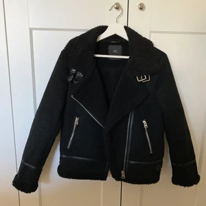 Bikerjacka  - Svart bikerjacka med teddytyg på insidan och detaljer. I fint skick och storlek S från Zara 