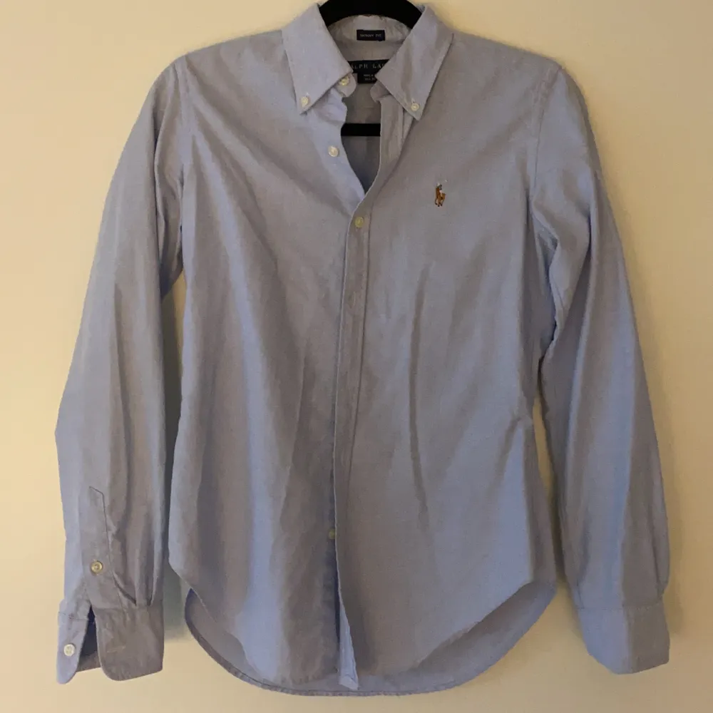 Ralph Lauren skjorta i storlek 4 (XS) i ljusblå färg. Fint skick.. Skjortor.