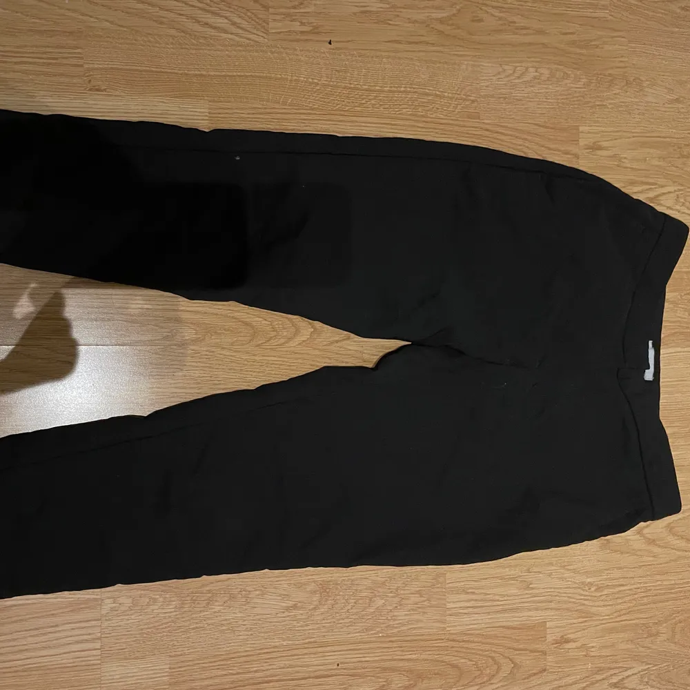 Svarta tajta kostymbyxor från H&M med slits i benet. Köparen står själv för frakten . Jeans & Byxor.