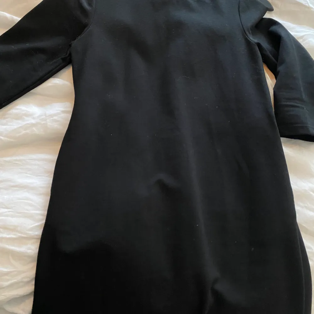 Snygg svart kortare klänning med 3/4 ärm. Oanvänd. Snygg att ha över skinnbyxor eller med strumpbyxor. Klänningar.