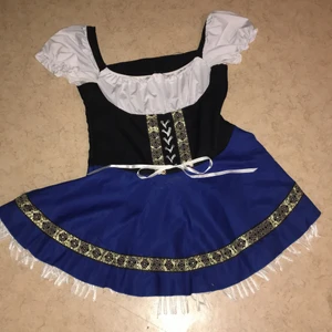 Oktoberfestklänning  - Oktoberfestklänning med blå kjol och guldiga detaljer. Vitt platt snöre som snöras i midjan och knyts själv. Använd fåtal gånger, i gott skick.  