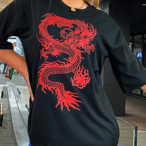 Svart oversize t shirt men en röd drake  - Svart oversize t shirt men en röd drake. Använt en gång skönt material jättefin men tvär för stör för mig. 
