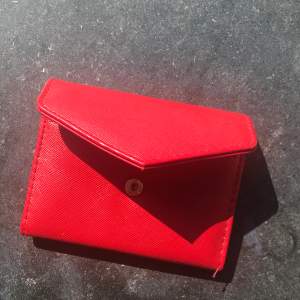 Röd plånbok/korthållare, vet ej märke. Perfekt liten smidig korthållare som man även kan få plats med annat som tuggumipaket eller nycklar i. Köparen står för frakt💕
