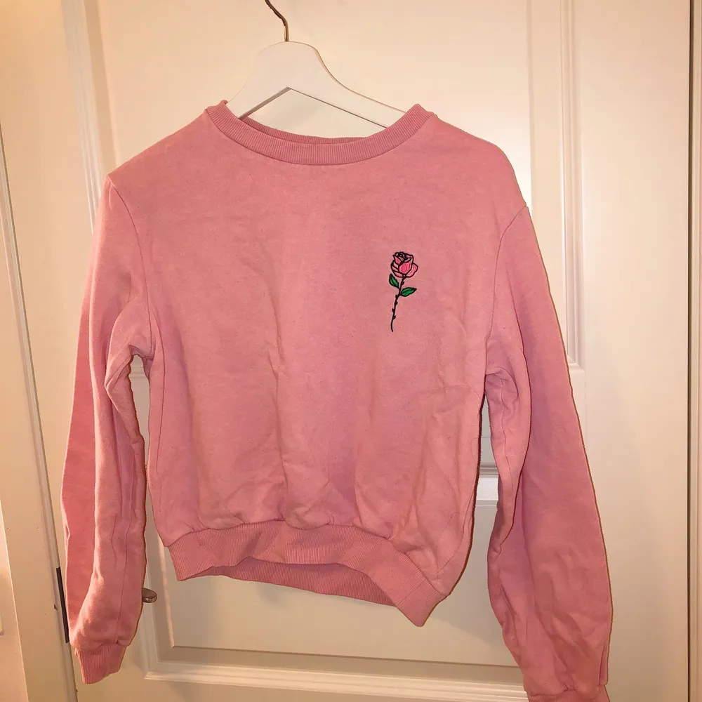 Rosa sweatshirt med en ros på, superfin färg och knappt använd. Är i storlek XS men passar även en S. 50kr plus frakt eller bud!!. Tröjor & Koftor.