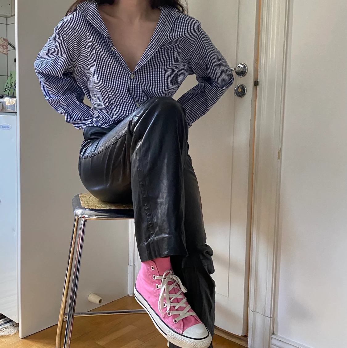 Rutig skjorta och skinnbyxor.