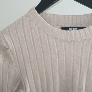 Tröja från bikbok - Superfin beige tröja i stretchigt material. Köpt i somras men har knappt kommit till användning. Tröjan är en tajtare modell och har en slits vid armarna.