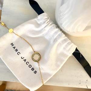 Äkta Marc Jacobs armband i guld med vit platta. Syns att armbandet är användt men annars inga fel på det. Strl går att justera 