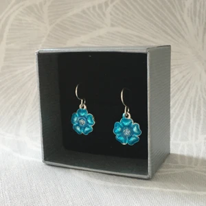 Örhängen  - Säljer dom här fina örhängena som föreställer blåa blommor men som även har en fin liten diamant i mitten. Aldrig använda.