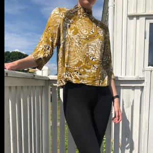 Mönstrad Blus - Blus i guldaktikt mönster från HM, strl 38 🖤 mycket fint skick. Kan mötas upp eller frakta. OBS! Köparen står för frakt och betalning sker via Swish 💕