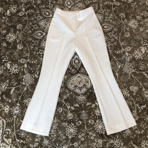 Vita kostymbyxor  - Högmidjade kostymbyxor använda endast en gång! De är uppsydda och är Innerbenslängd 70cm men kan sys ner till 74cm. Midjemåttet är 71cm. (Köparen står för frakten) 🌜
