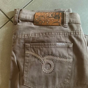 Bruna jeans med strass - Säljer dessa superfina byxor eftersom jag beställde dom online och dom tyvärr var lite för små för mig <\3 superfin brun färg och vida/bootcut ben. Passar nog en 38/40 och någon som är ungefär 165-170 lång 